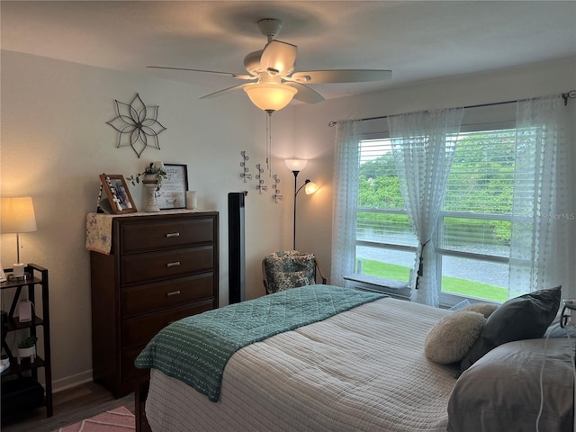 bedroom featuring hardwood / wood-style flooring, multiple windows, and ceiling fan