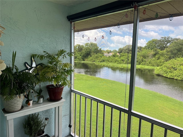 unfurnished sunroom featuring a water view