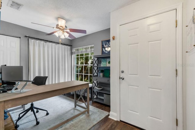 office space featuring a textured ceiling, ceiling fan, and dark wood-type flooring