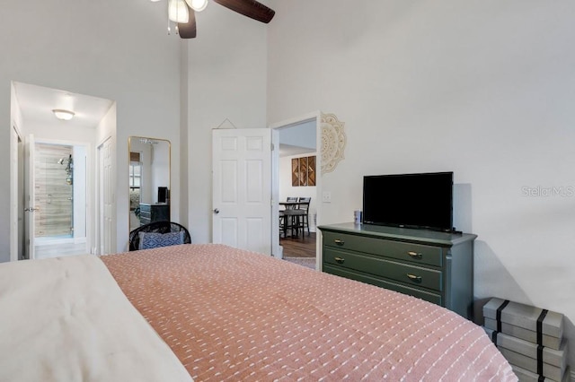 bedroom with ceiling fan and a towering ceiling