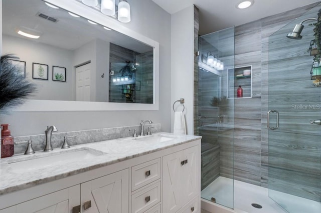 bathroom with vanity and a shower with door