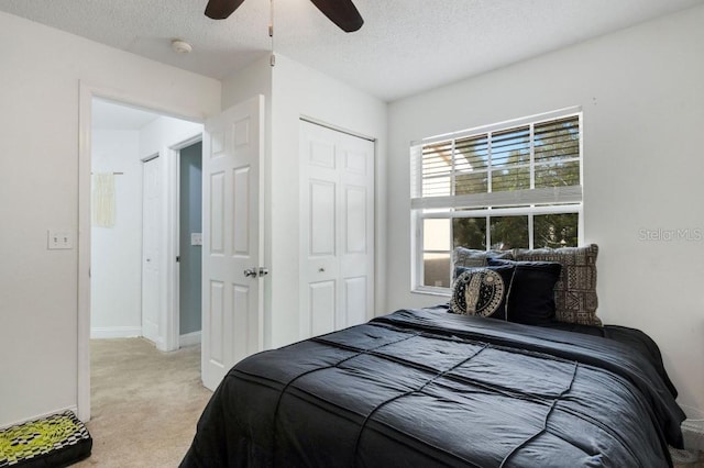 carpeted bedroom with a textured ceiling, a closet, and ceiling fan