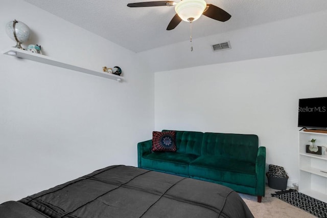 carpeted bedroom with ceiling fan and a textured ceiling