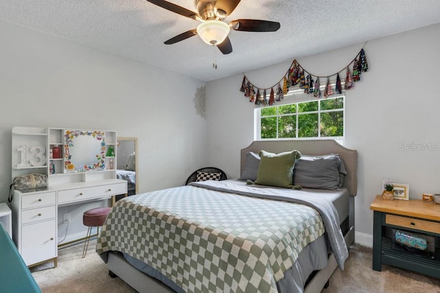 bedroom with ceiling fan, light colored carpet, and a textured ceiling