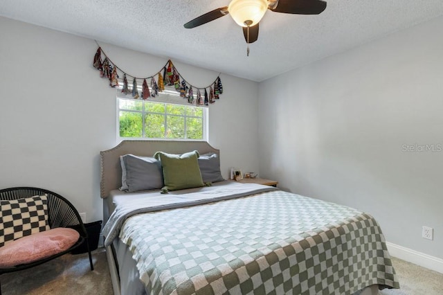 carpeted bedroom featuring ceiling fan and a textured ceiling