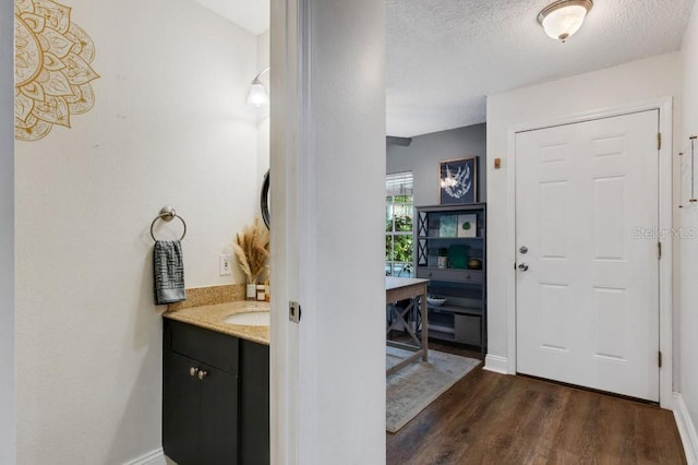 entrance foyer featuring a textured ceiling, dark hardwood / wood-style flooring, and sink