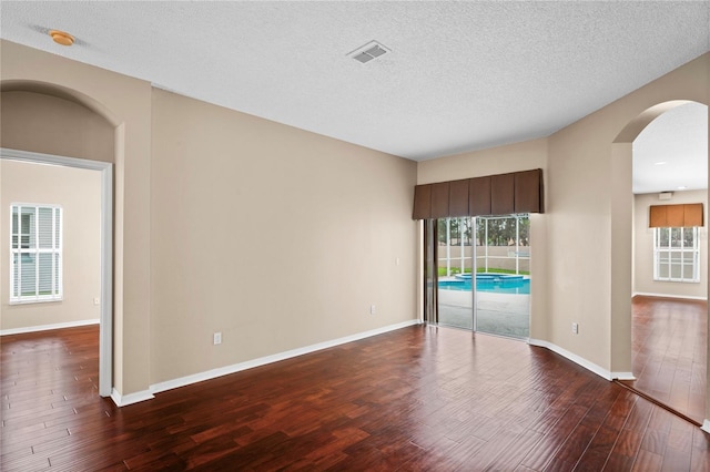 spare room featuring wood-type flooring and a textured ceiling