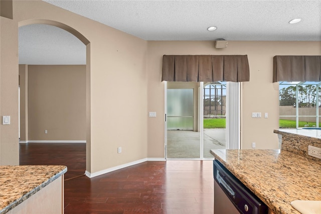 kitchen featuring light stone counters, a textured ceiling, dishwasher, and dark hardwood / wood-style flooring