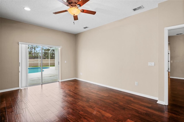 spare room with ceiling fan, dark hardwood / wood-style floors, and a textured ceiling