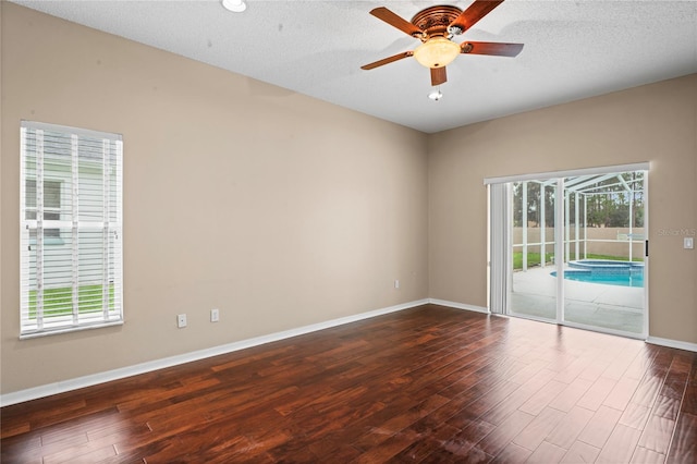 unfurnished room featuring dark wood-type flooring, a textured ceiling, and ceiling fan