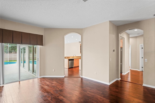 spare room with sink, hardwood / wood-style flooring, and a textured ceiling