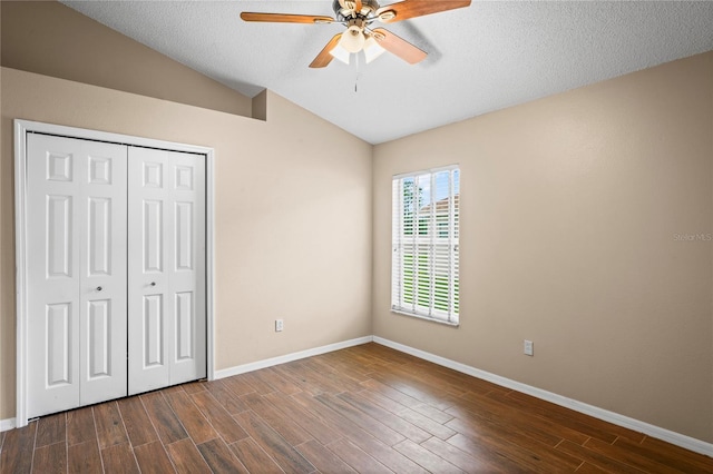 unfurnished bedroom featuring lofted ceiling, a textured ceiling, a closet, and ceiling fan