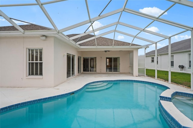 view of swimming pool featuring an in ground hot tub, a patio area, glass enclosure, and ceiling fan