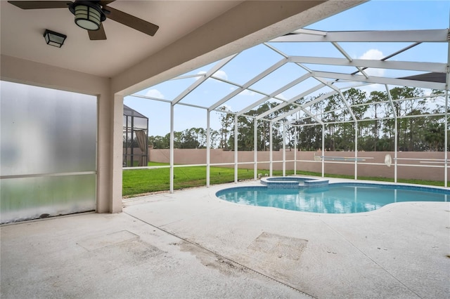 view of pool with glass enclosure, ceiling fan, an in ground hot tub, a yard, and a patio area