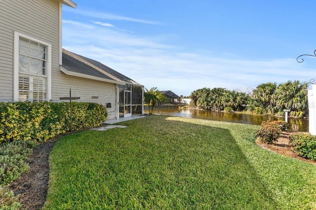 view of yard featuring a lanai and a water view