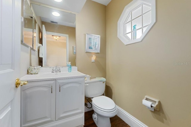 bathroom with hardwood / wood-style flooring, vanity, and toilet