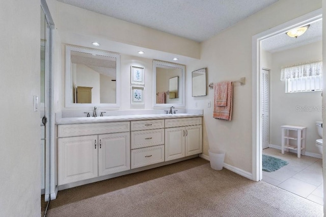 bathroom with vanity, tile patterned floors, a textured ceiling, and toilet