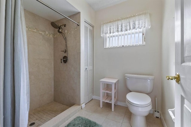 bathroom featuring toilet, curtained shower, and tile patterned flooring