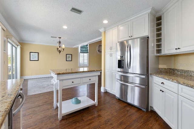 kitchen featuring white cabinetry, stainless steel appliances, hanging light fixtures, and light stone counters