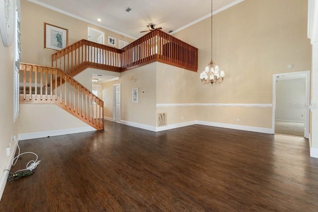 unfurnished living room with crown molding, dark wood-type flooring, a high ceiling, and ceiling fan with notable chandelier