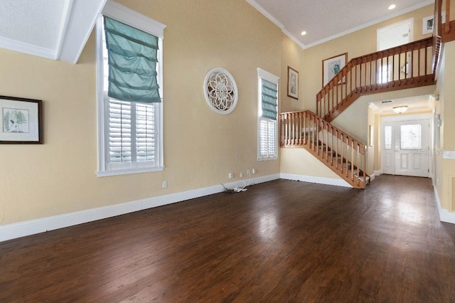 unfurnished living room with crown molding, dark hardwood / wood-style floors, and a towering ceiling