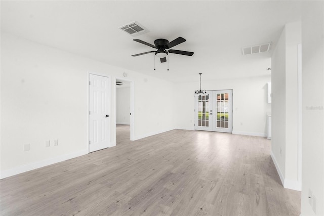 unfurnished room with light hardwood / wood-style flooring, ceiling fan with notable chandelier, and french doors