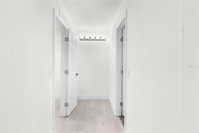 corridor with light hardwood / wood-style floors