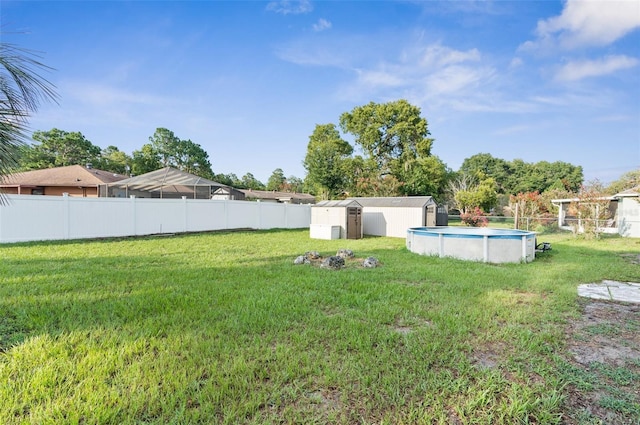 view of yard featuring a fenced in pool and a shed