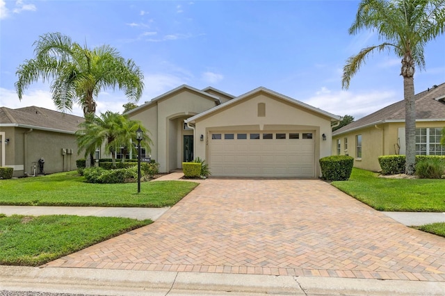 view of front facade with a front lawn, decorative driveway, an attached garage, and stucco siding