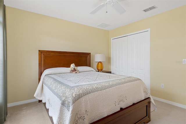 bedroom featuring light carpet, ceiling fan, and a closet