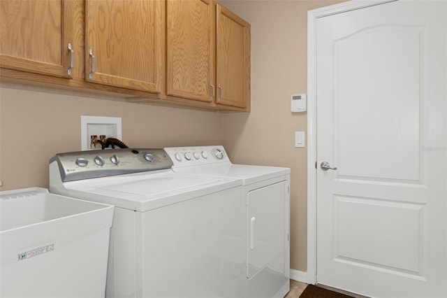 laundry area with cabinets, separate washer and dryer, and sink