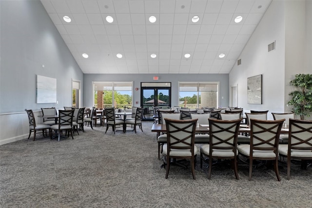 dining room with dark carpet and a high ceiling