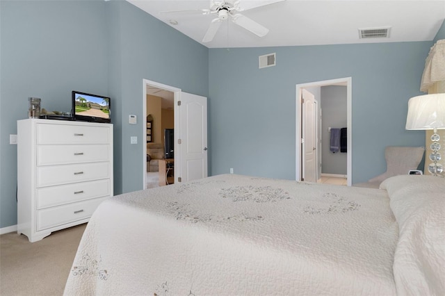 carpeted bedroom featuring lofted ceiling, ceiling fan, and ensuite bath