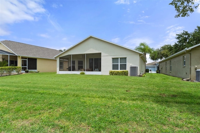 back of property with a sunroom, a yard, and central AC