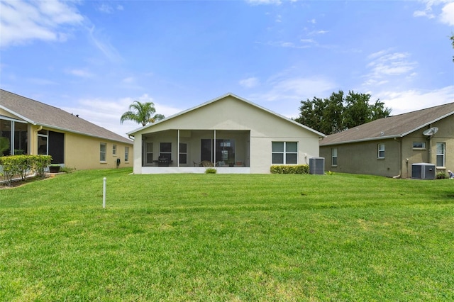 rear view of property featuring a sunroom, a lawn, and central air condition unit