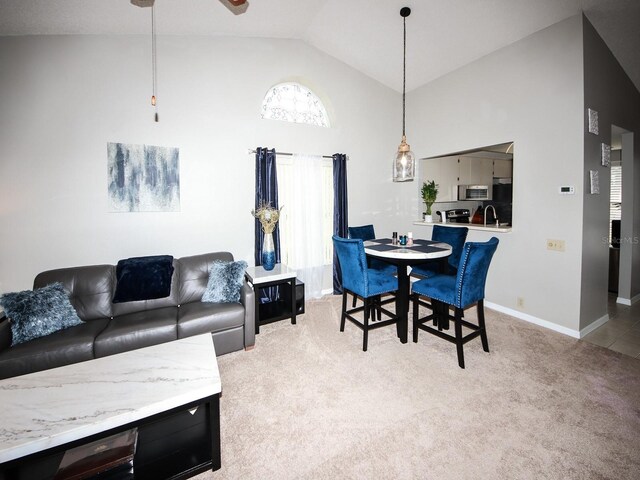 carpeted dining room with high vaulted ceiling