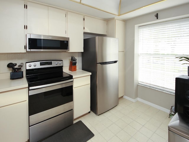 kitchen featuring decorative backsplash, stainless steel appliances, and white cabinets