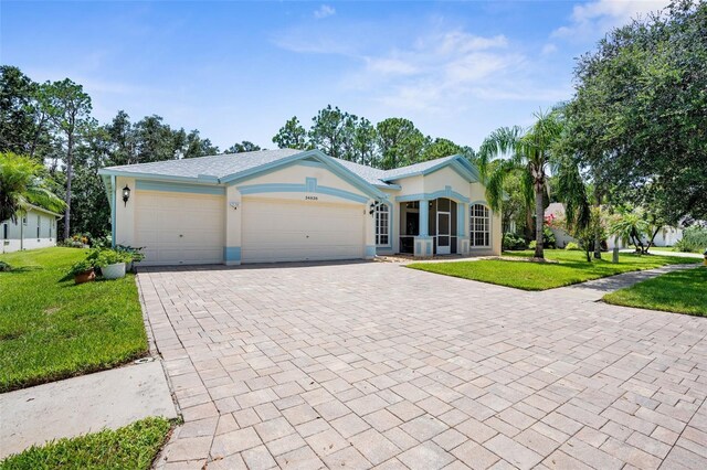 single story home with a garage and a front lawn