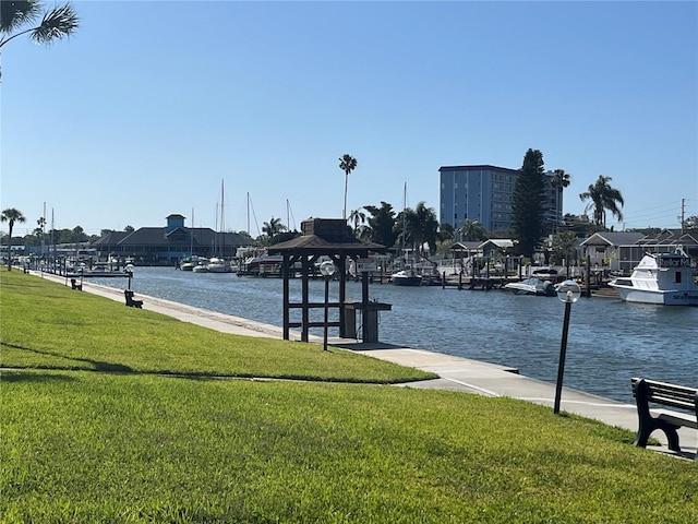 view of dock with a yard and a water view