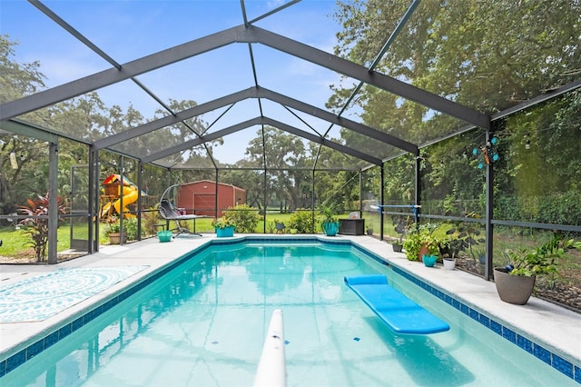 view of pool featuring glass enclosure, an outdoor structure, and a patio area