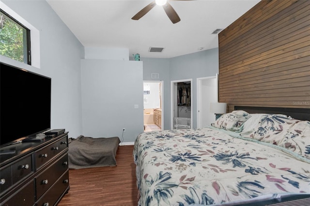 bedroom with dark hardwood / wood-style flooring, a spacious closet, ensuite bath, a closet, and ceiling fan