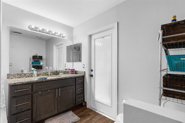 bathroom featuring vanity, toilet, and hardwood / wood-style flooring