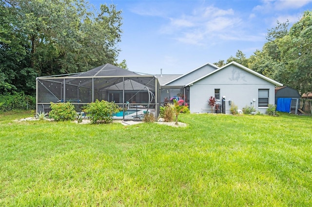 back of house with glass enclosure and a yard