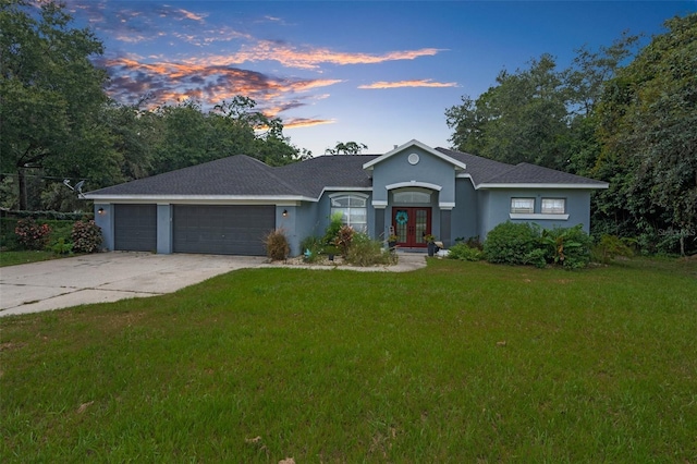 ranch-style home with a lawn and a garage