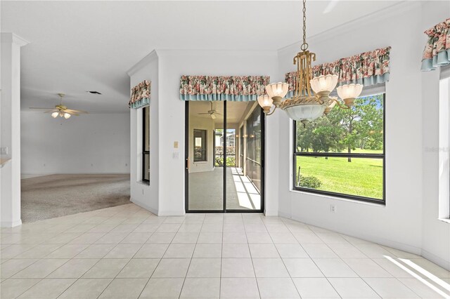 unfurnished dining area featuring ceiling fan with notable chandelier, light tile patterned floors, and a healthy amount of sunlight