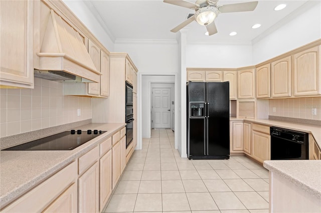 kitchen with black appliances, backsplash, light brown cabinetry, and premium range hood