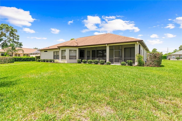 rear view of house featuring a sunroom and a yard