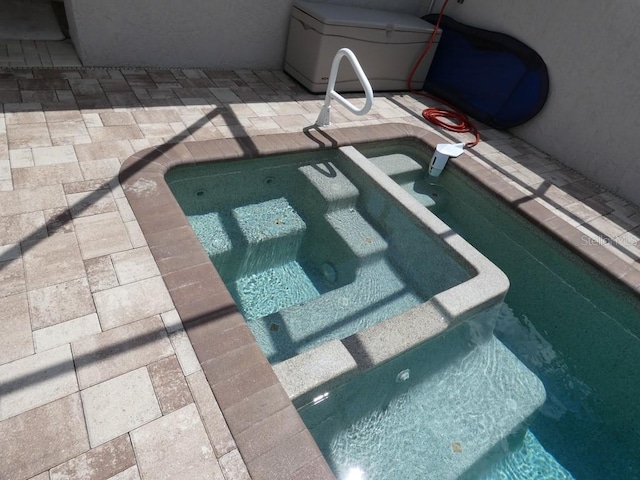 view of pool featuring an in ground hot tub