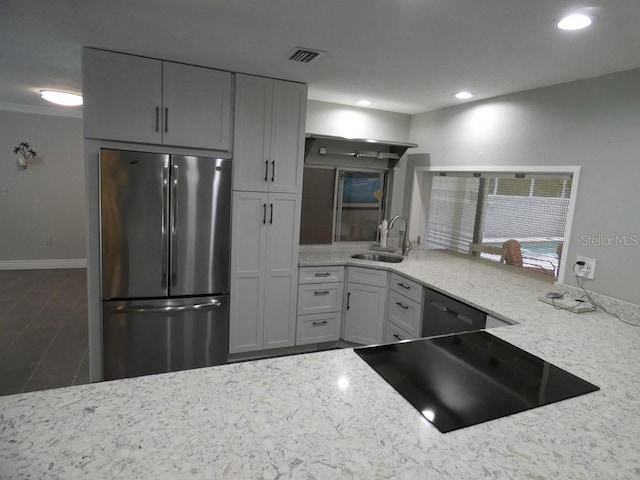 kitchen with stainless steel refrigerator, white cabinetry, light stone countertops, sink, and black dishwasher