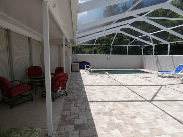 view of swimming pool with glass enclosure and a patio area